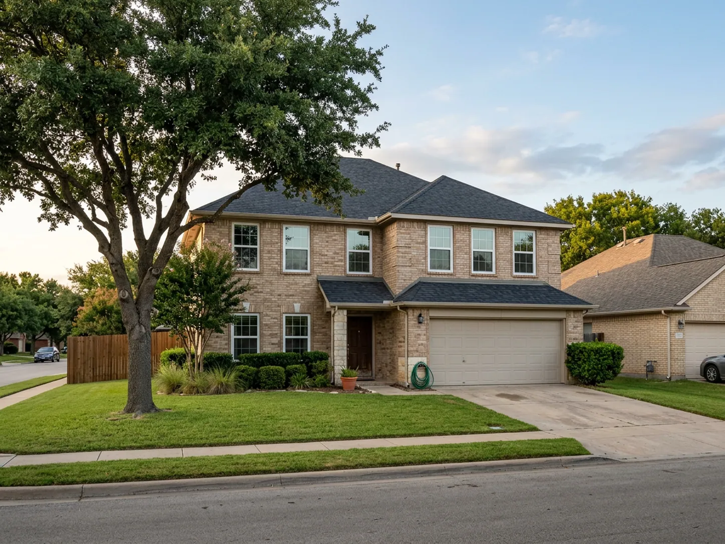 Two-story brick home in a North Texas neighborhood with new white-framed replacement windows