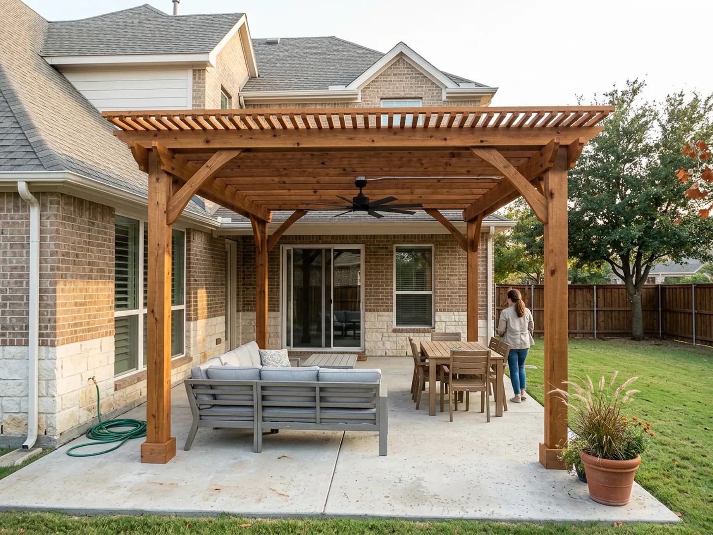 Wood pergola with a ceiling fan over an outdoor seating area on a North Texas patio