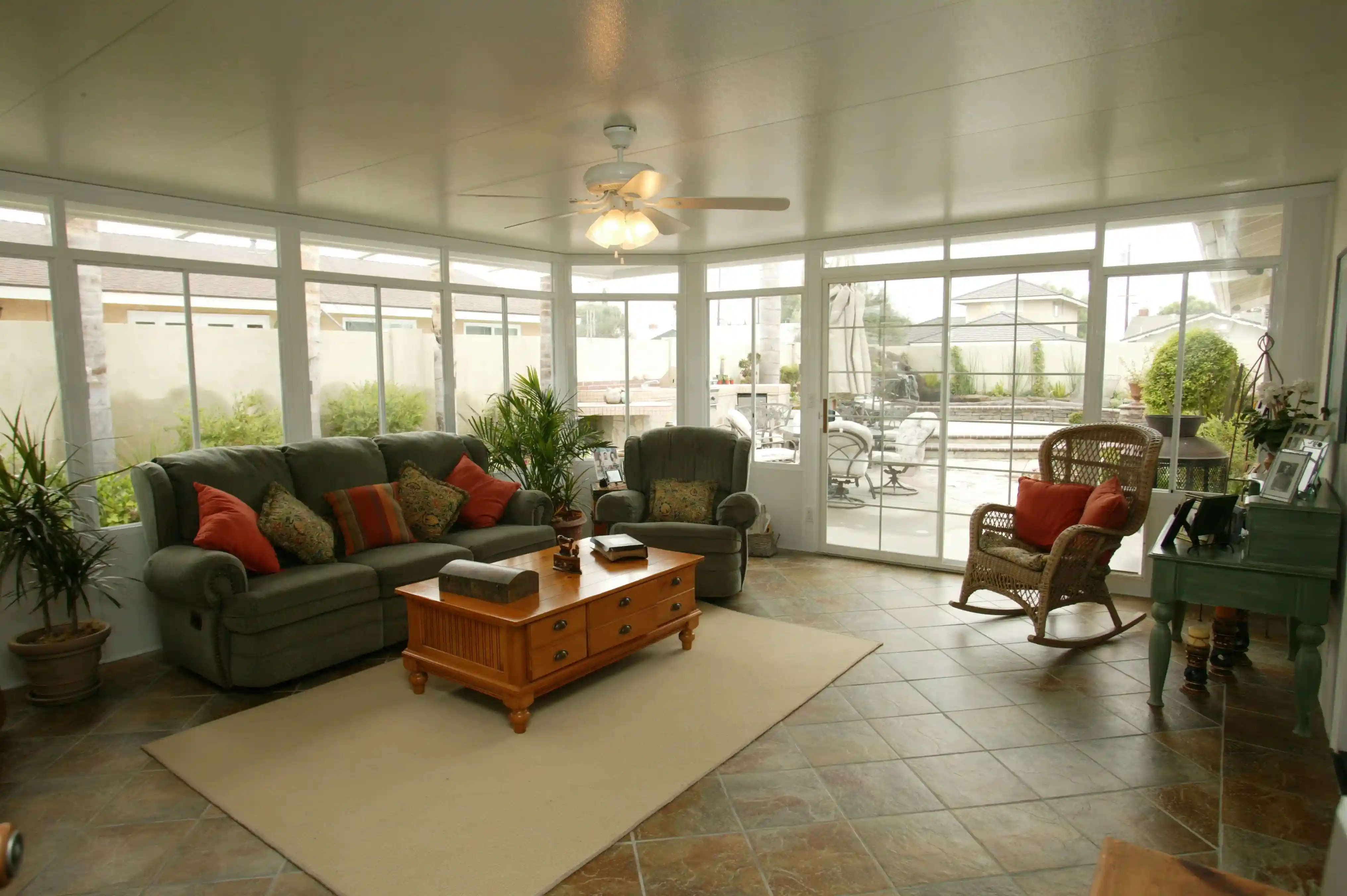 Screened porch seating area with furniture and a ceiling fan
