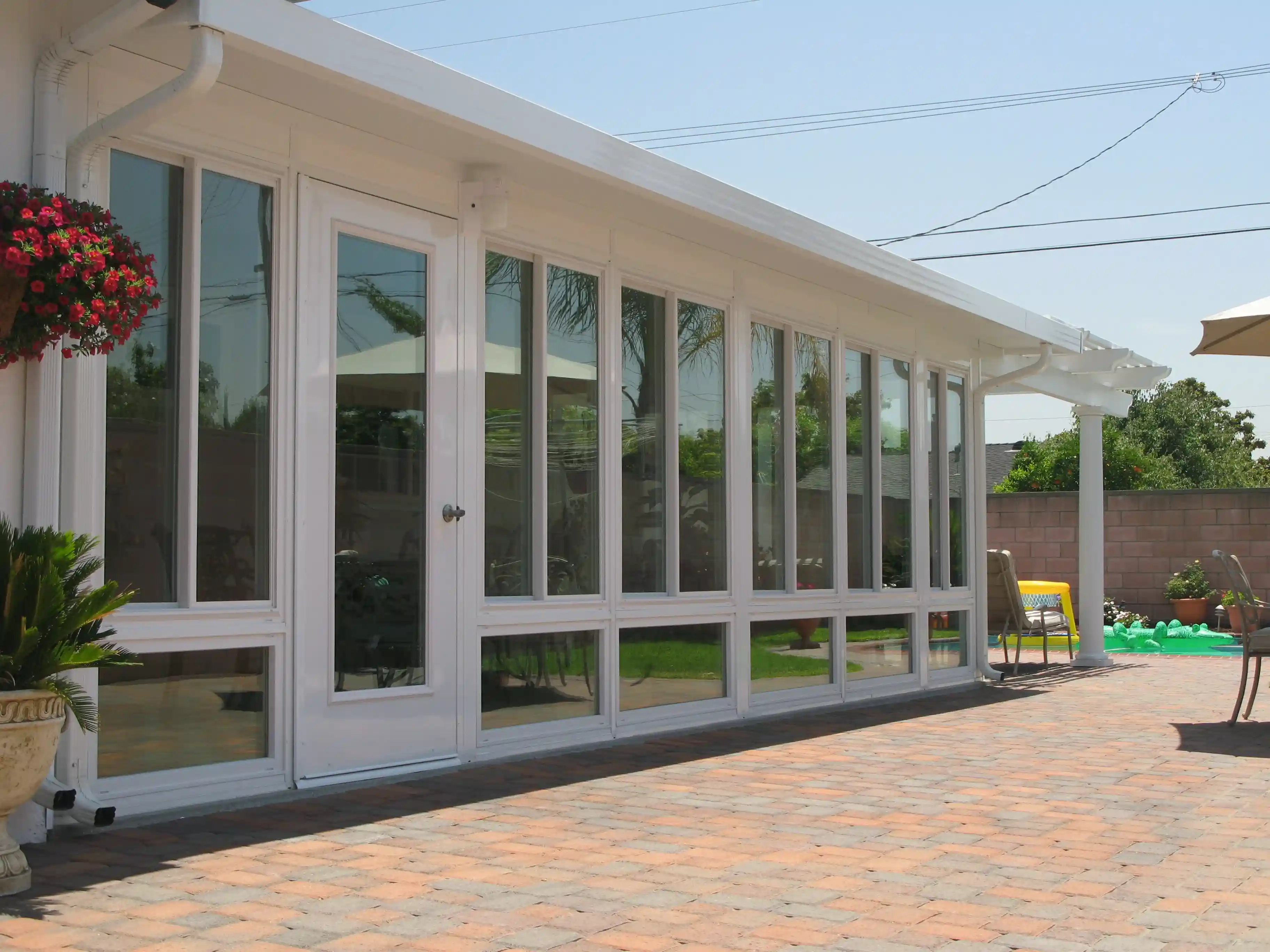 Long sunroom addition along a paved patio