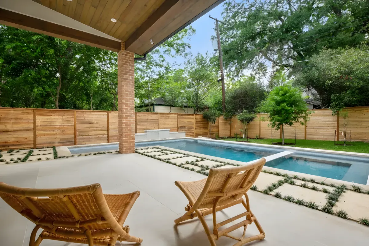 Cedar-ceilinged covered patio with lounge chairs looking out to a pool