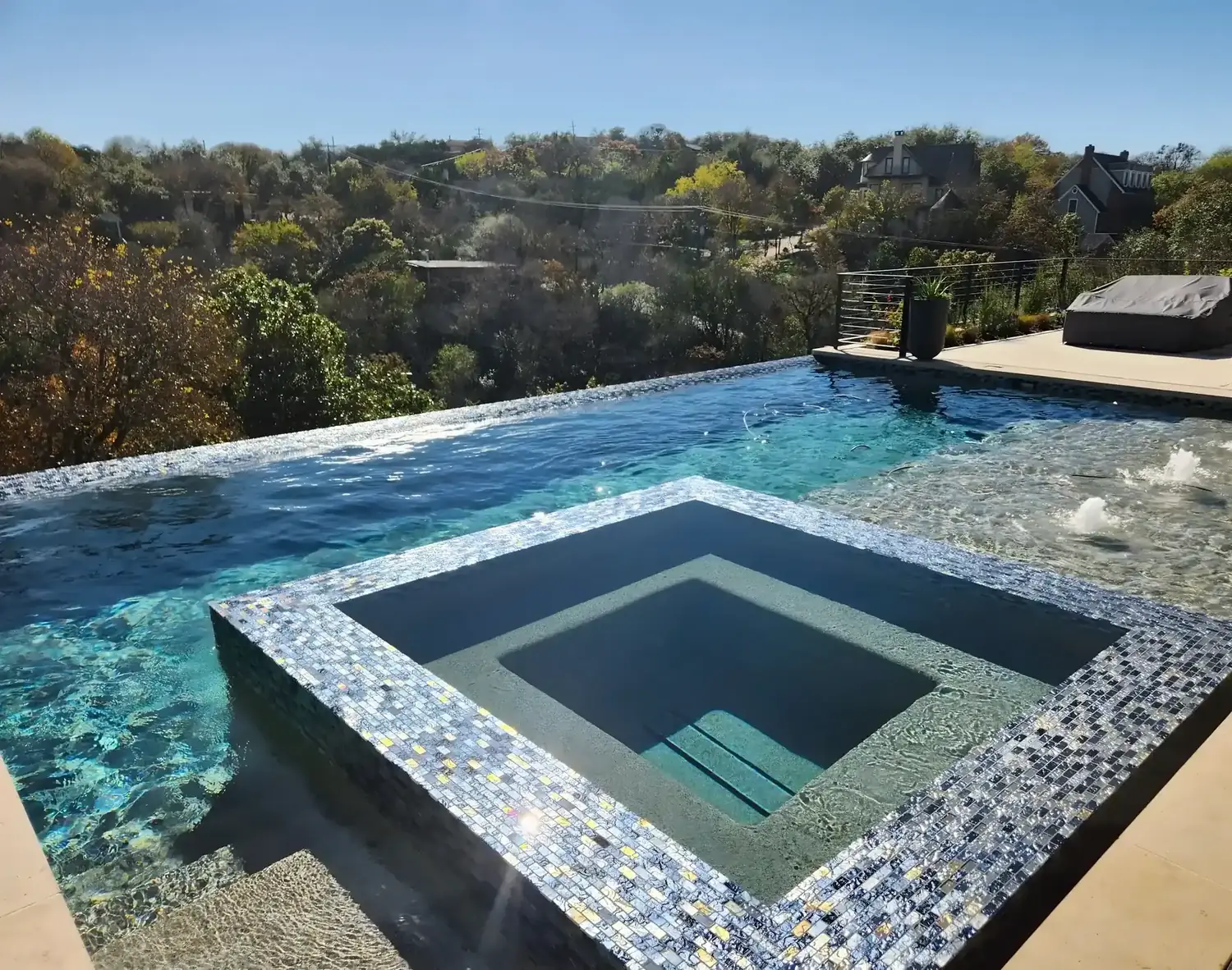 Infinity-edge pool and glass-tile spa overlooking the treetops