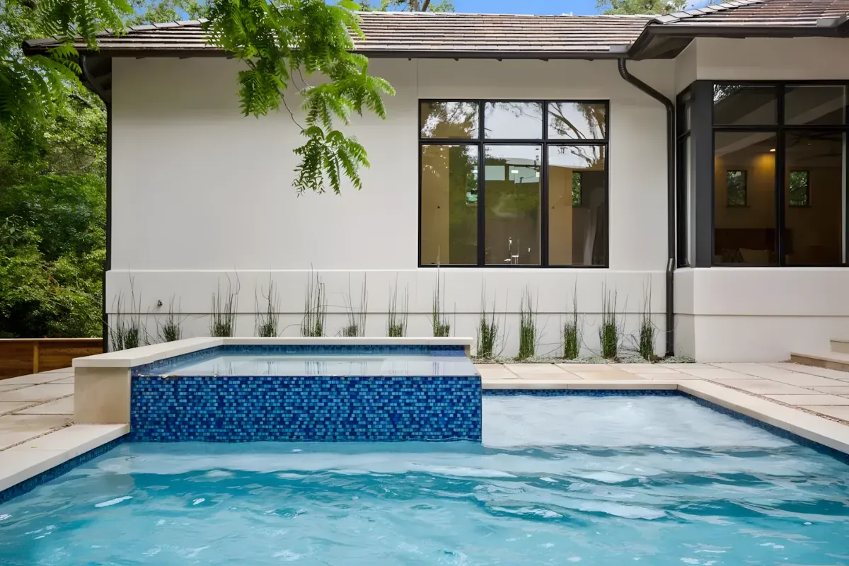 Pool edged in flagstone paving under a mature oak