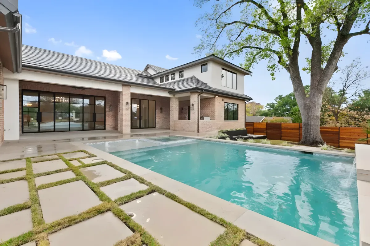 Pool and paver deck shaded by a sprawling live oak