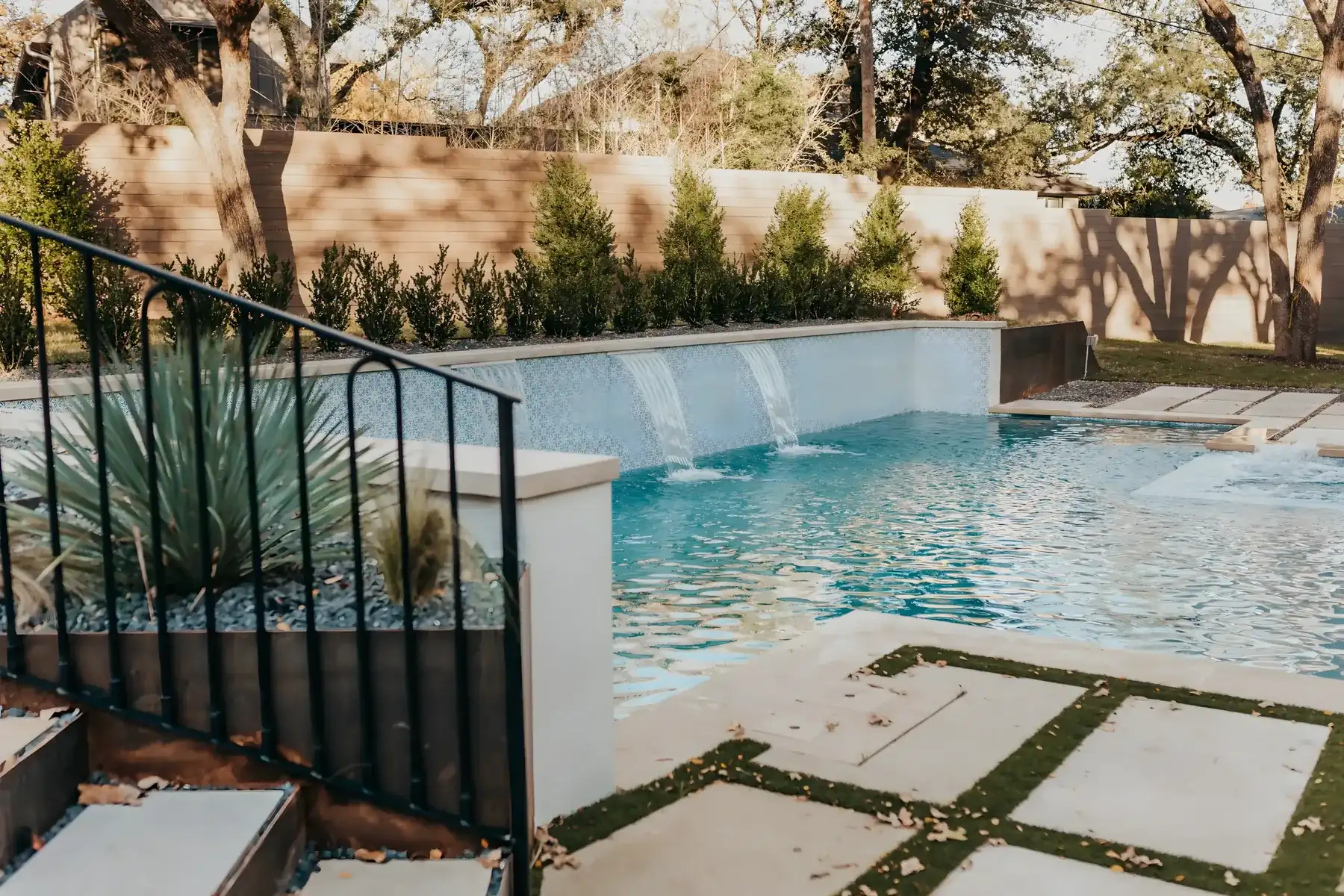 Sheer-descent waterfalls and stone steps beside a pool