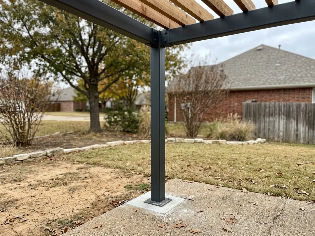 Steel pergola post and beam with cedar slats on a concrete footing in a clay-soil yard