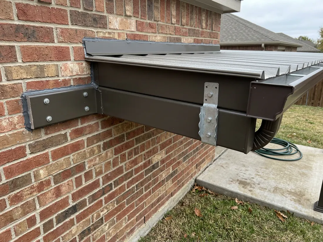 Close view of patio cover ledger and flashing fastened to a brick house wall