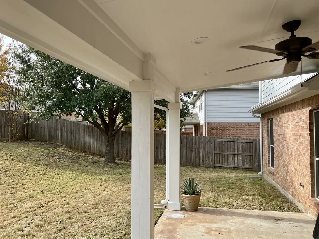 Heavy white column and finished ceiling making a patio cover look built into a brick house