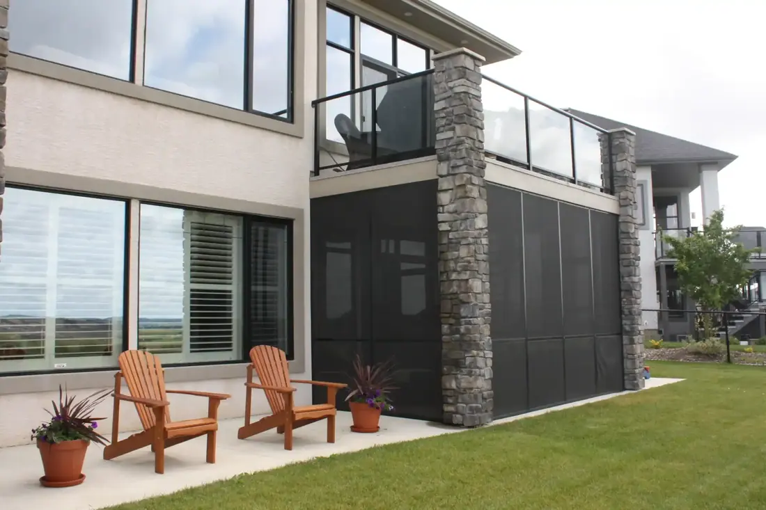 Screened patio enclosure under a second-story deck, with stone columns