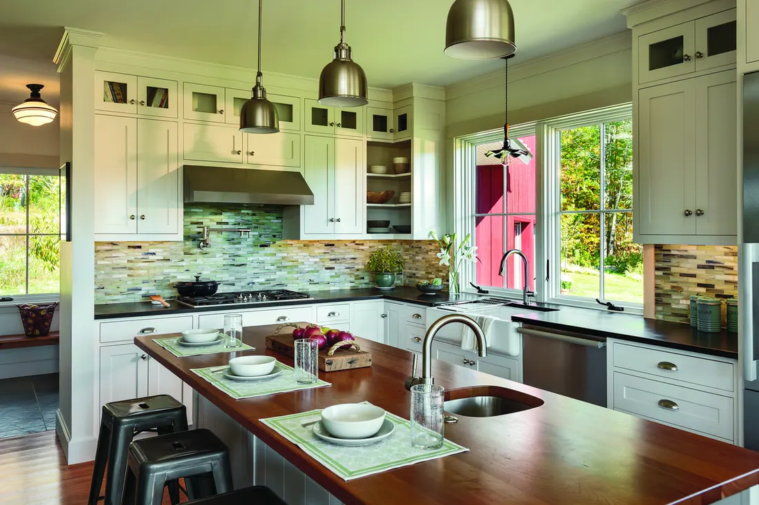 White casement windows with grids above a kitchen sink overlooking a green yard