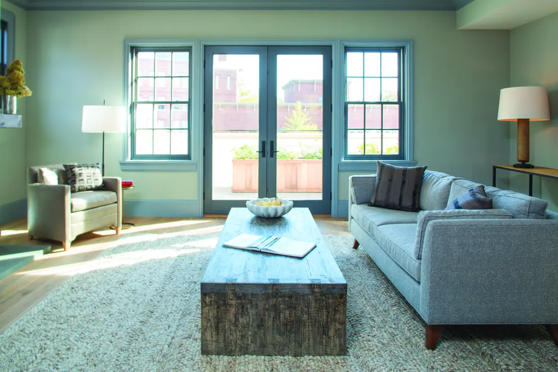 Blue-trimmed grid windows and French patio doors in a modern light green living room