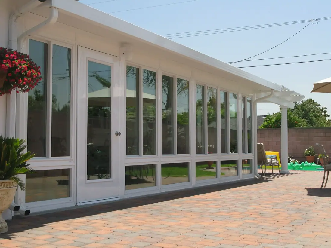 Long sunroom addition along a paved patio