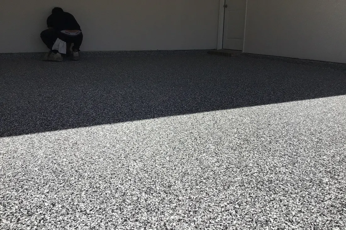 Gray and white speckled epoxy flake coating applied to a garage concrete floor