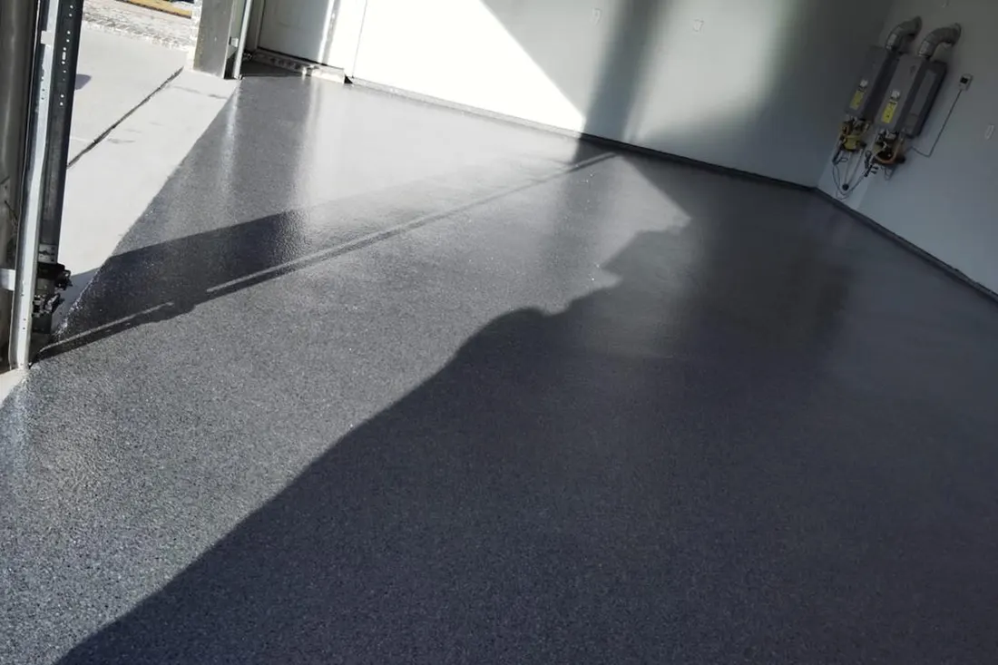 Glossy gray epoxy flake coating applied across a clean residential garage floor