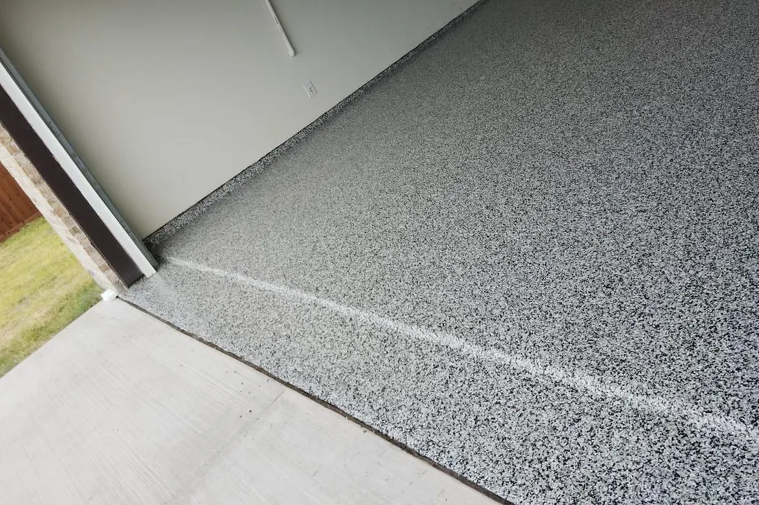 Garage floor and step coated in a speckled gray, white, and black flake finish