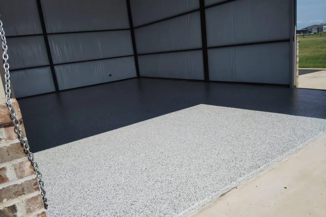 Gray speckled epoxy flake coating on an open garage workshop concrete floor
