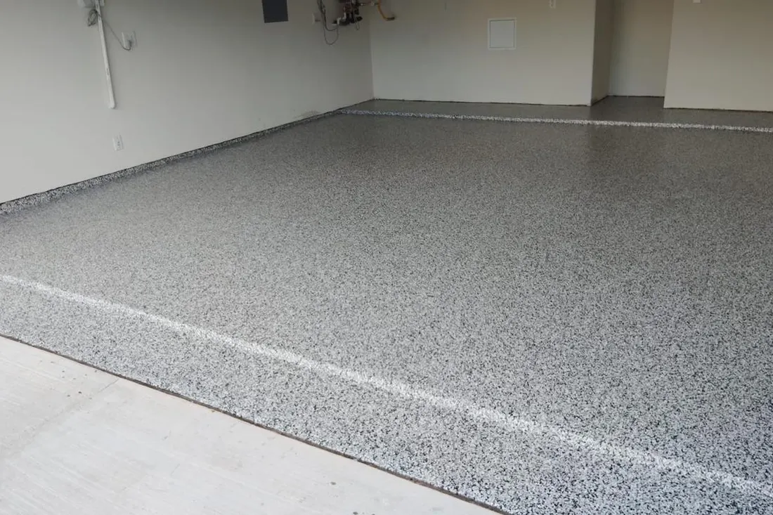 Gray and white speckled epoxy flake garage floor coating inside an empty residential garage