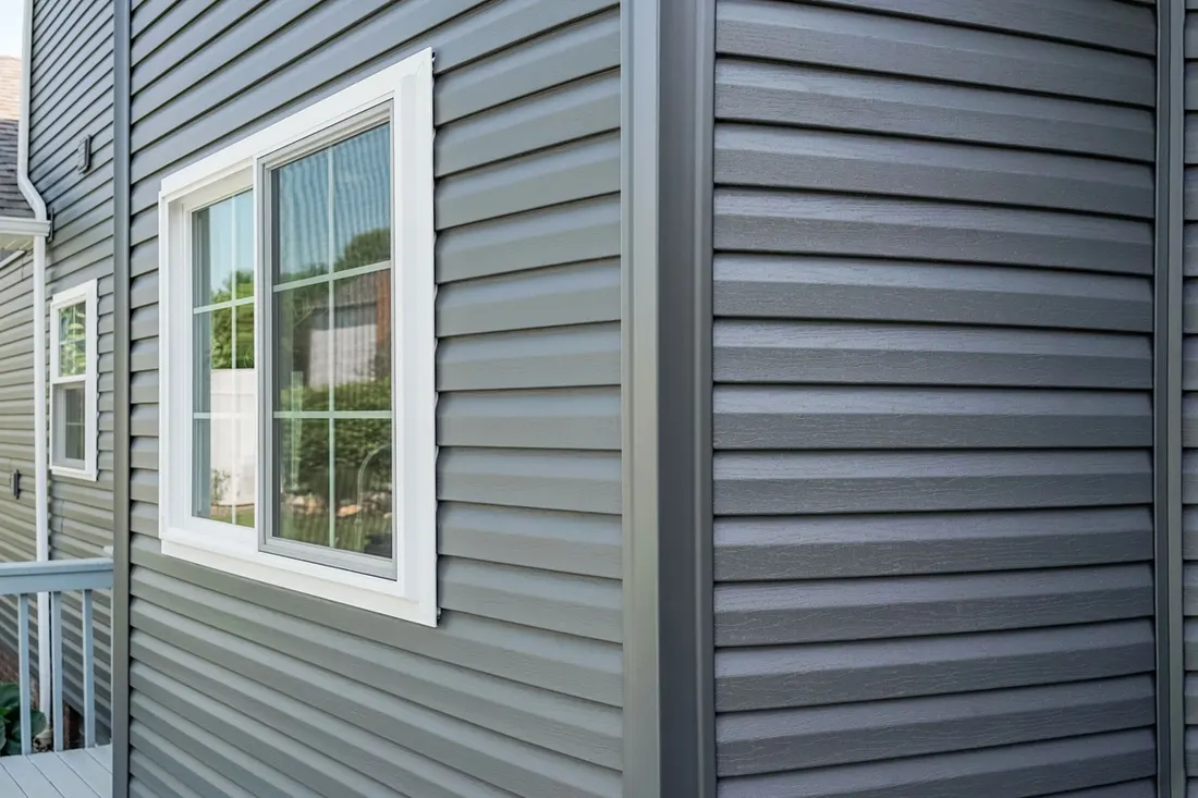 Dark gray horizontal lap siding on home exterior next to a white-trimmed window