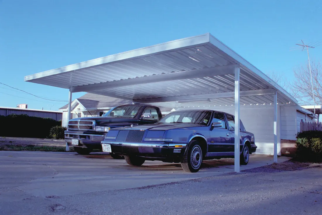 White metal carport covering two parked vehicles on a concrete driveway