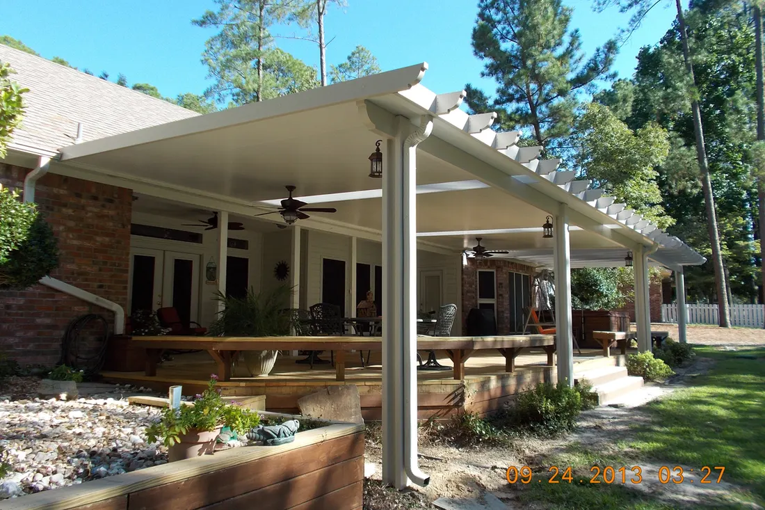 White solid patio cover with decorative pergola trim over a backyard raised wooden deck