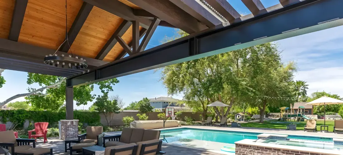Steel-and-cedar pergola over a poolside patio lounge