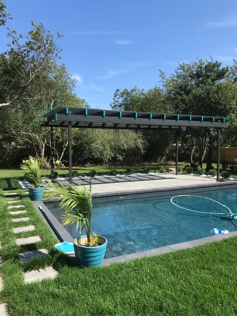 Black pergola with teal accents over a stone patio beside a backyard swimming pool