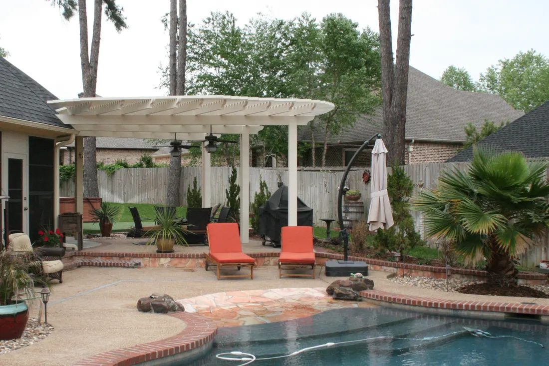 White wooden pergola with orange chairs beside a swimming pool and landscaped patio