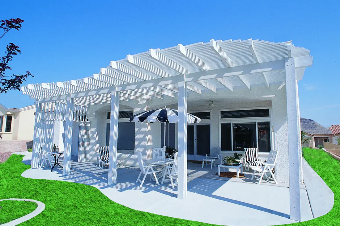 White-painted pergola with slatted roof, patio furniture, and lattice sides beside a green lawn