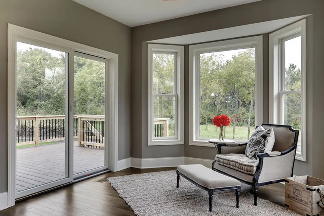Living room with a sliding glass door and bay window onto a deck