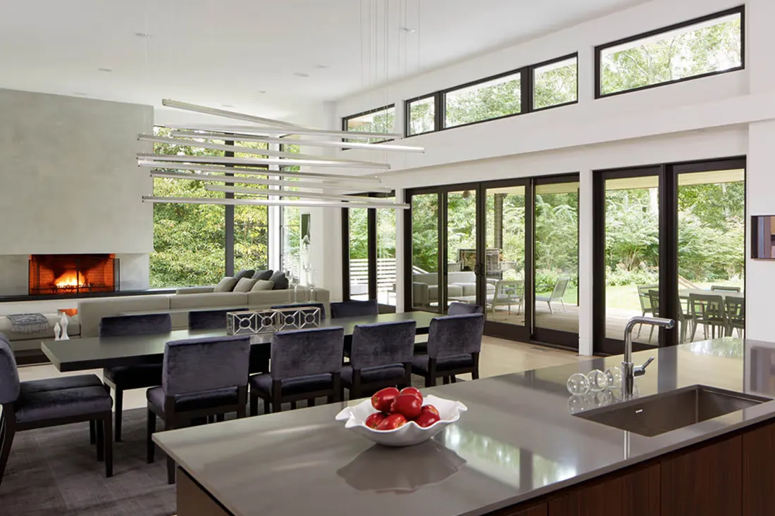 Open kitchen and dining room lined with tall sliding glass doors