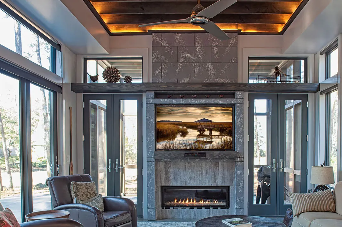 Living room with glass doors flanking a stone fireplace and TV