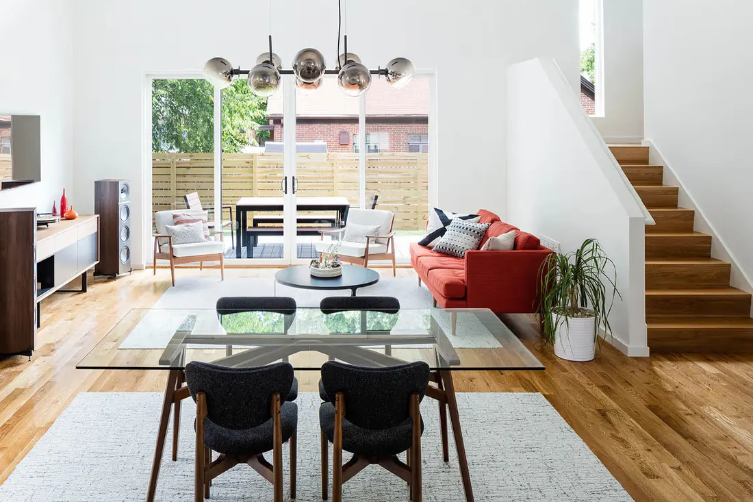 Bright dining area with sliding glass doors and a red sofa
