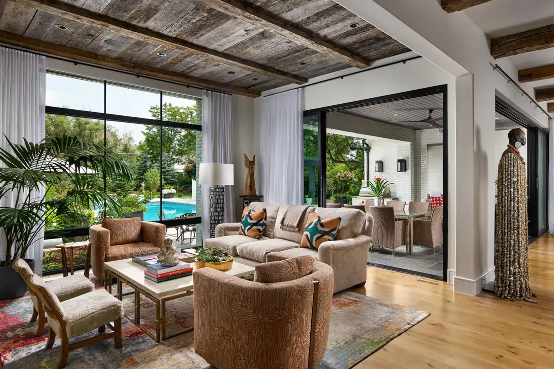 Living room with floor-to-ceiling glass doors opening to a pool