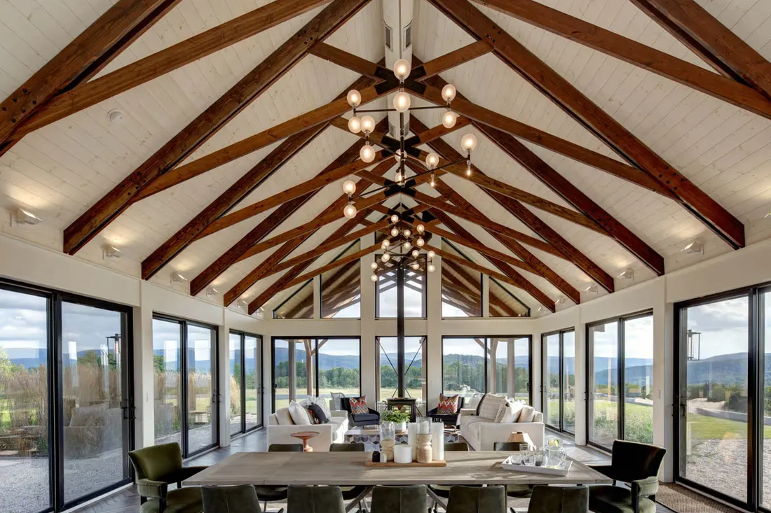 Vaulted dining room with timber beams and walls of glass doors