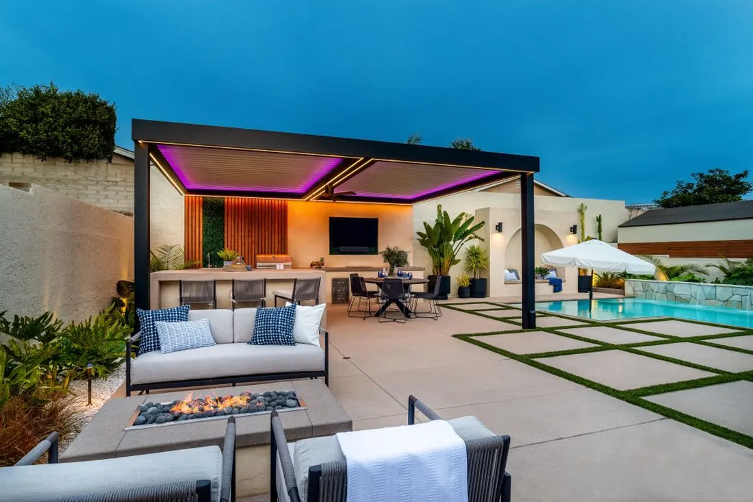 Pergola with purple lighting over an outdoor lounge beside a pool