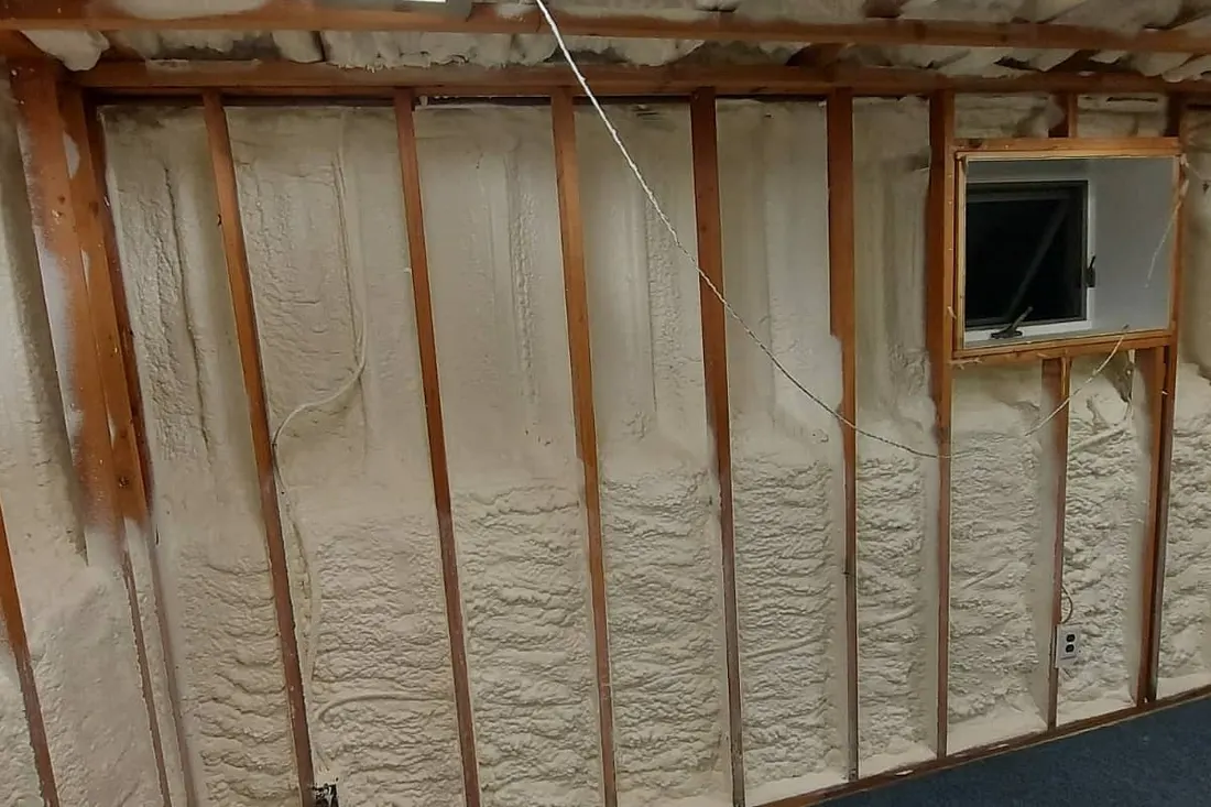Spray foam insulation sealing wall studs in an unfinished room