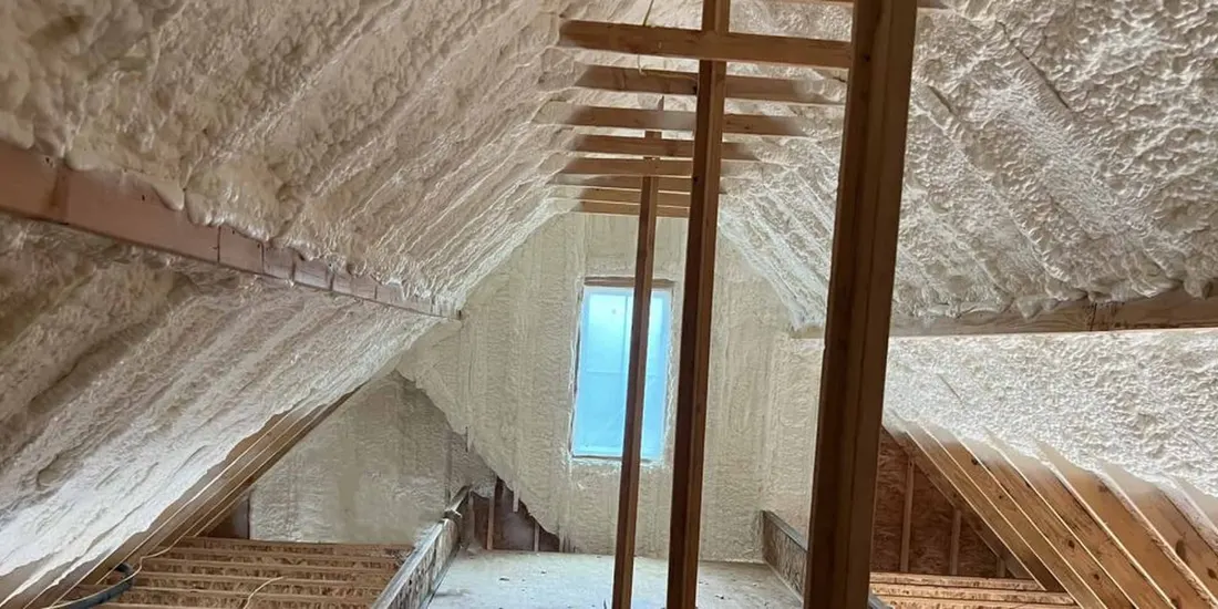 Spray foam insulation coating the underside of a sloped attic roof