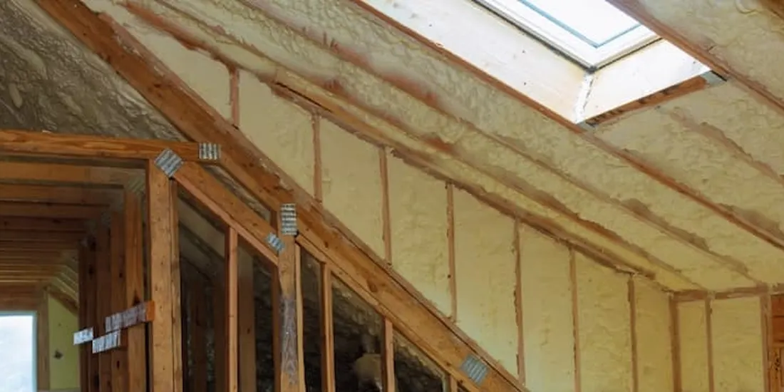 Spray foam insulation along a sloped ceiling with a skylight