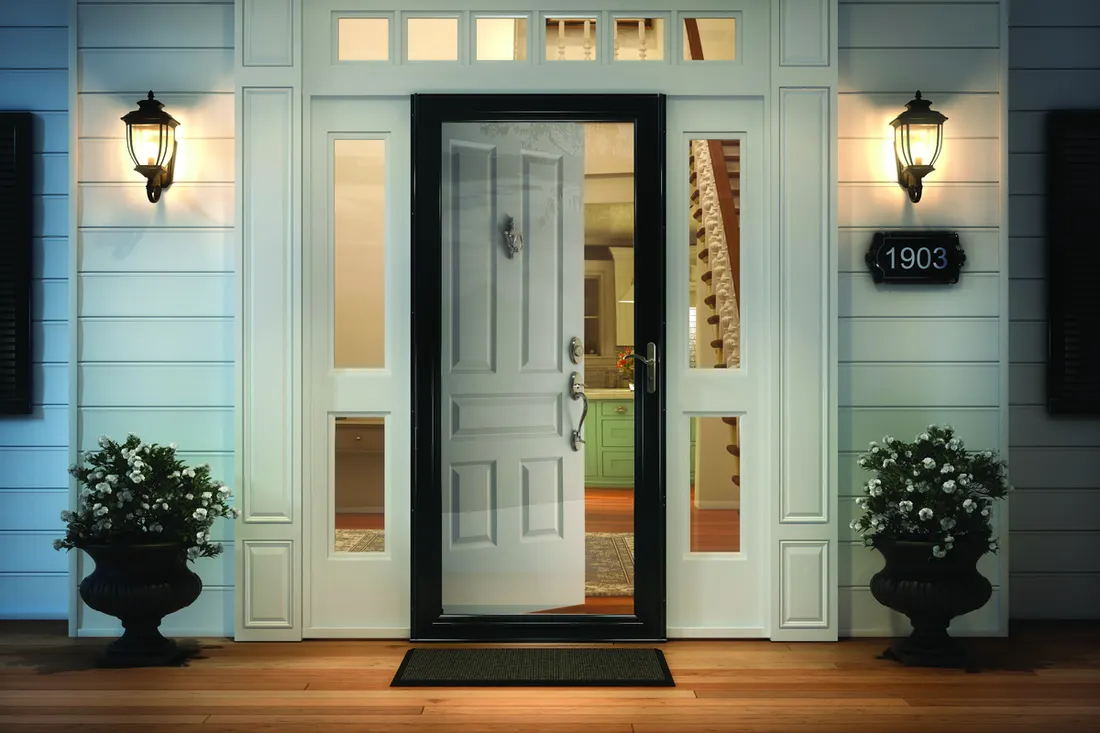 Black full-view glass storm door installed outside an open white front door with sidelights