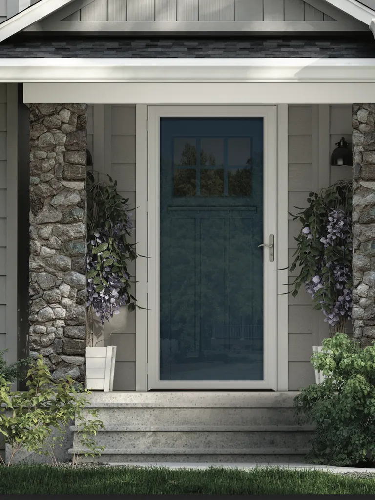 Teal storm door framed by stone columns at a home entry