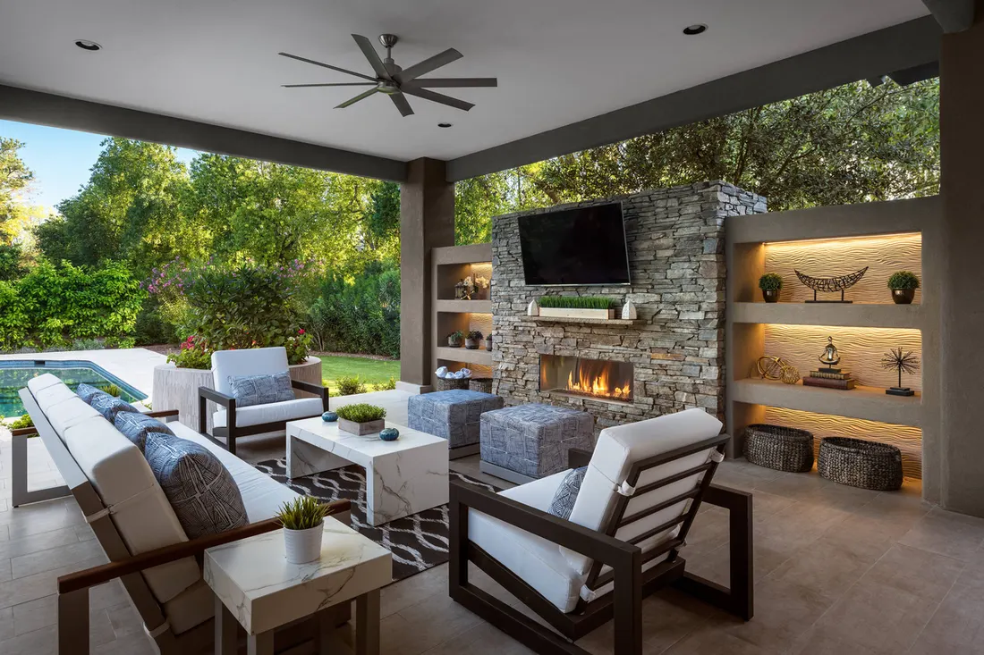Covered outdoor living room with fireplace, TV and lounge chairs