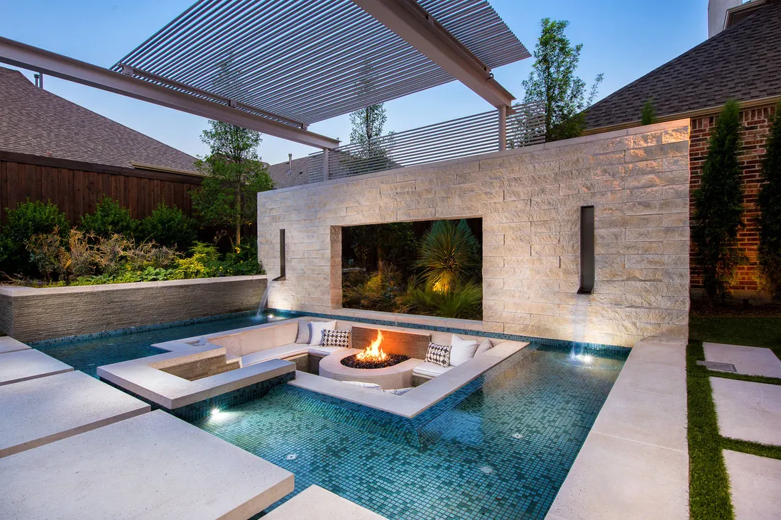Modern pool with a sunken fire pit lounge and stone feature wall