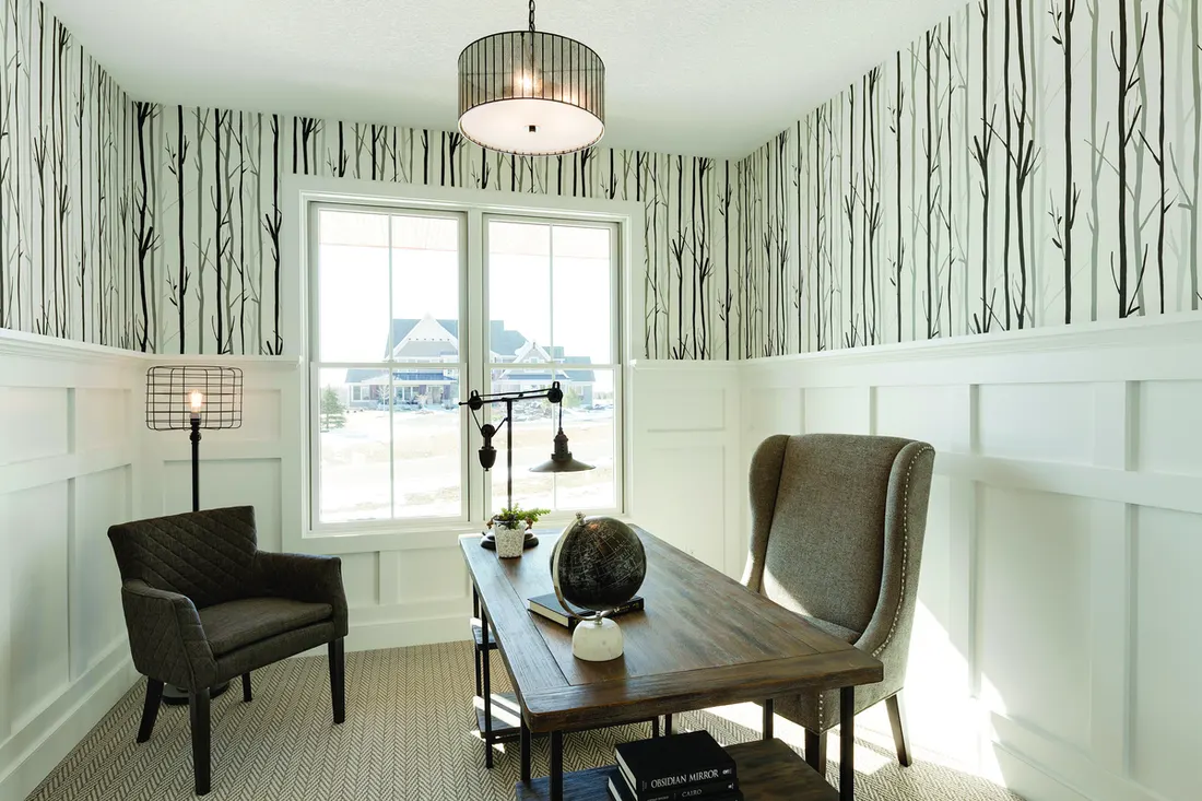 White double-hung windows with grilles in a home office featuring wainscoting and birch wallpaper